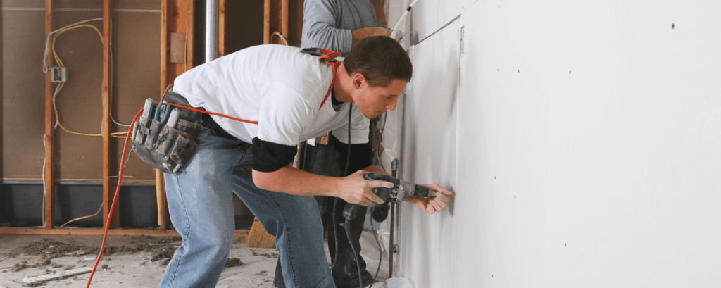 Carpenter saws through drywall