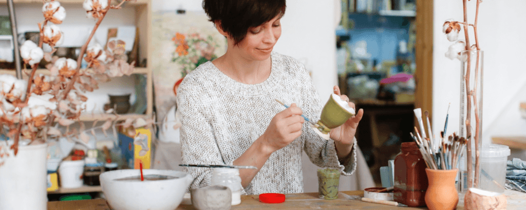 Pottery store owner paints mug