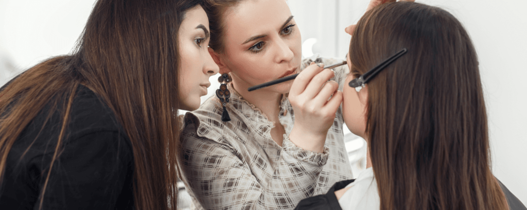 Beautician applies make-up to client