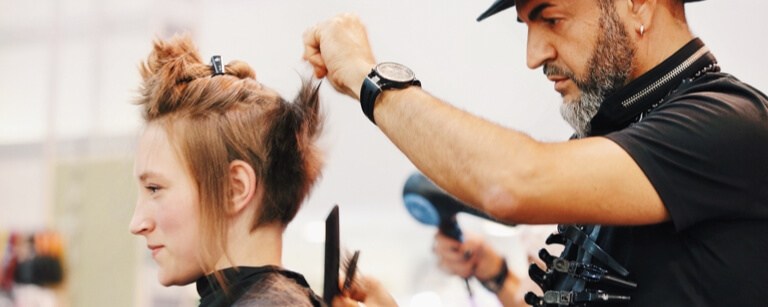 Hairstylist with hairstylist insurance is working with comb

