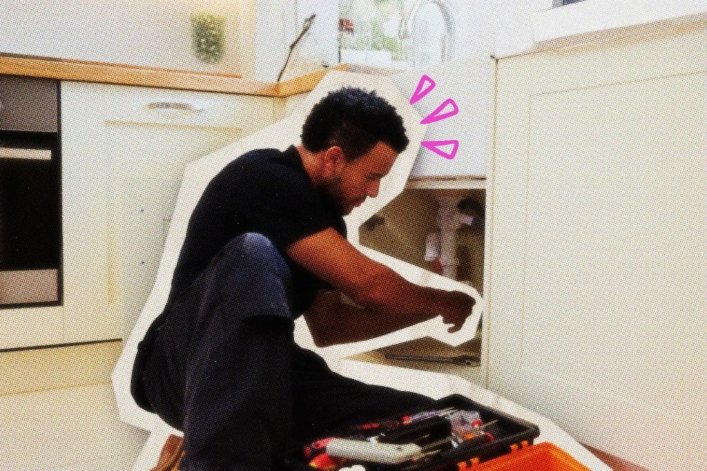 Plumber working under a kitchen sink