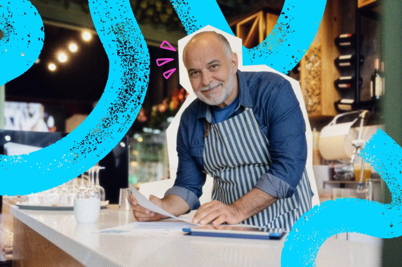 Restaurant owner working on his laptop at a counter.