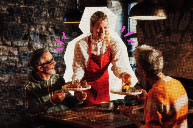 Waiter talking with two customers at a table.